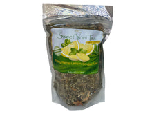 Load image into Gallery viewer, A sealed, silver bag of Sweet Yoni Tea which features a decorative label and a drawing of mint and lemons. The bag also features a large see-through window to view the contents of the bag. Inside of the bag is a variety of herbs.
